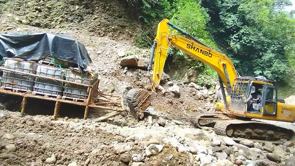 Escavadeira de esteira SH240-8 navega em terreno lamacento da floresta amazônica para transportar mercadorias para clientes sul-americanos